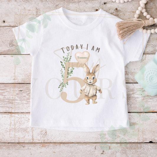 White t-shirt with a rabbit design and text on a wooden surface